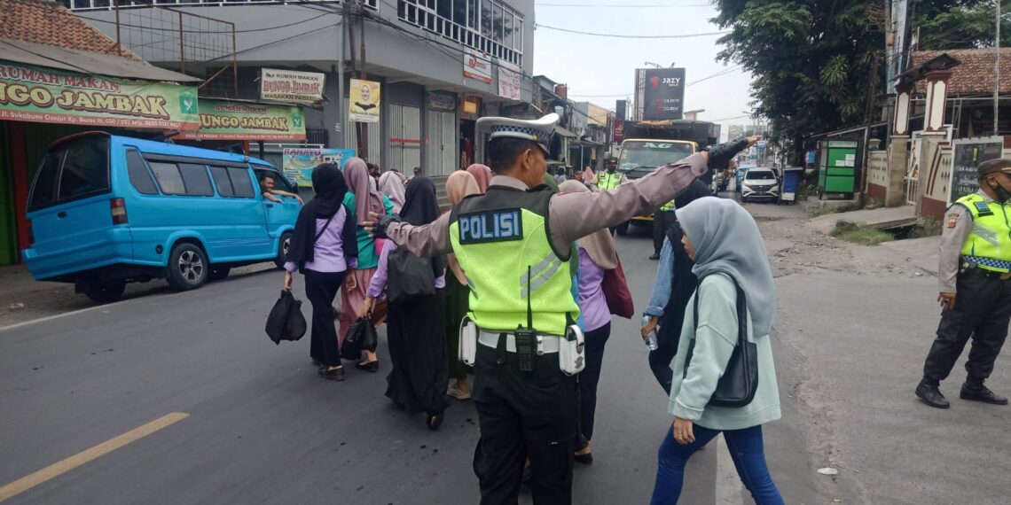 Wujud Kepedulian, Polisi Unit Lantas Polsek Sukalarang Bantu Masyarakat Menyeberang Jalan