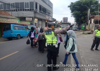 Wujud Kepedulian, Polisi Unit Lantas Polsek Sukalarang Bantu Masyarakat Menyeberang Jalan