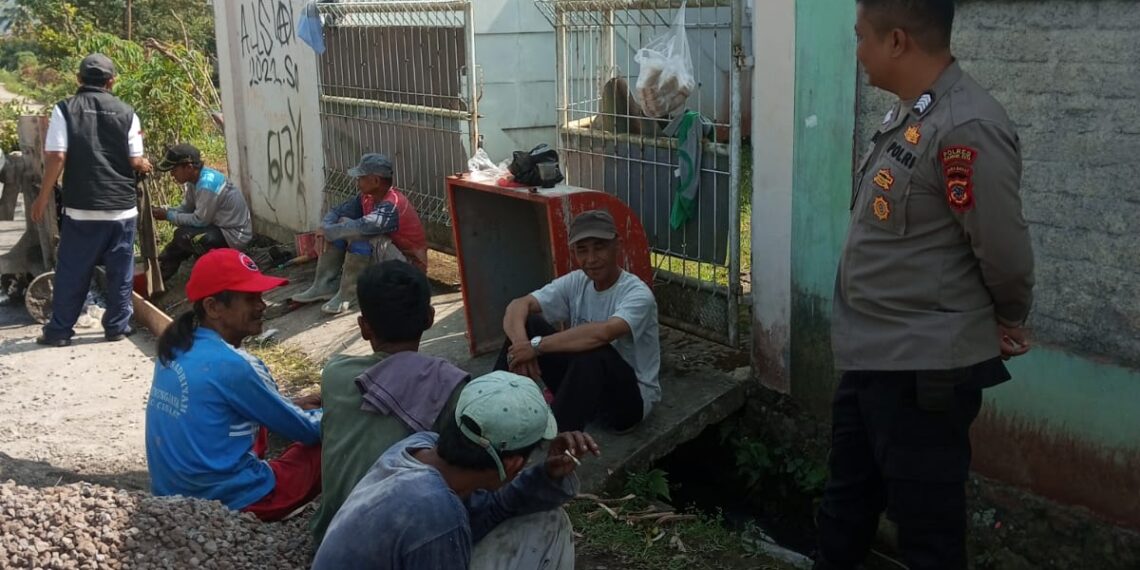 Bersama Warga, Bhabinkamtibmas Polsek Cisaat  monitoring  Pengaspalan Jalan Desa