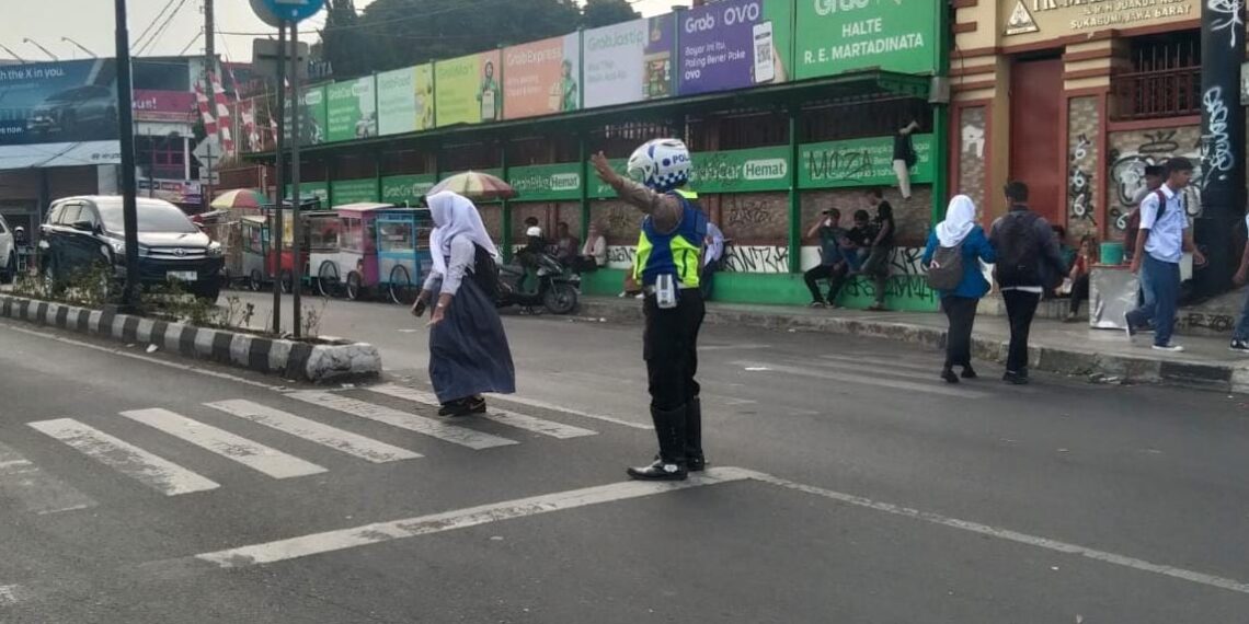 Pelayanan Pagi, Polsek Cikole Membantu Menyebrangkan Para Pelajar Yang Akan Berangkat Ke Sekolah