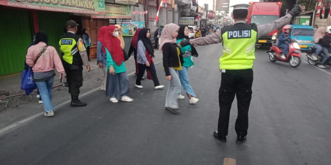 Wujud Kepedulian Demi Kelancaran Polisi Bantu Masyarakat Menyeberang Jalan