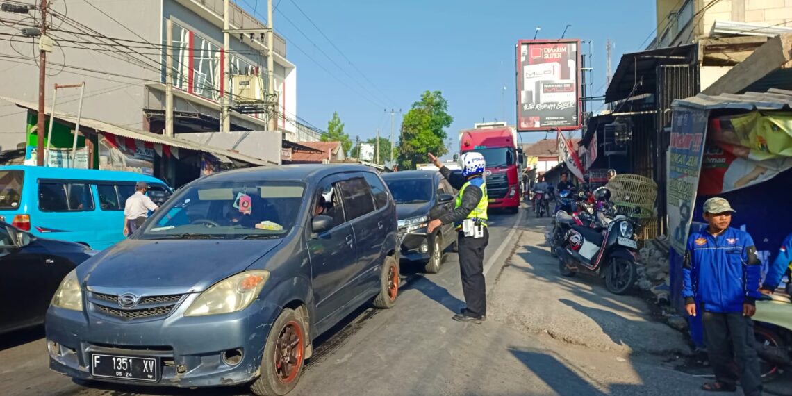 Ada Truk Mogok, Kanit Lantas Polsek Sukalarang membantu mengurai kemacetan