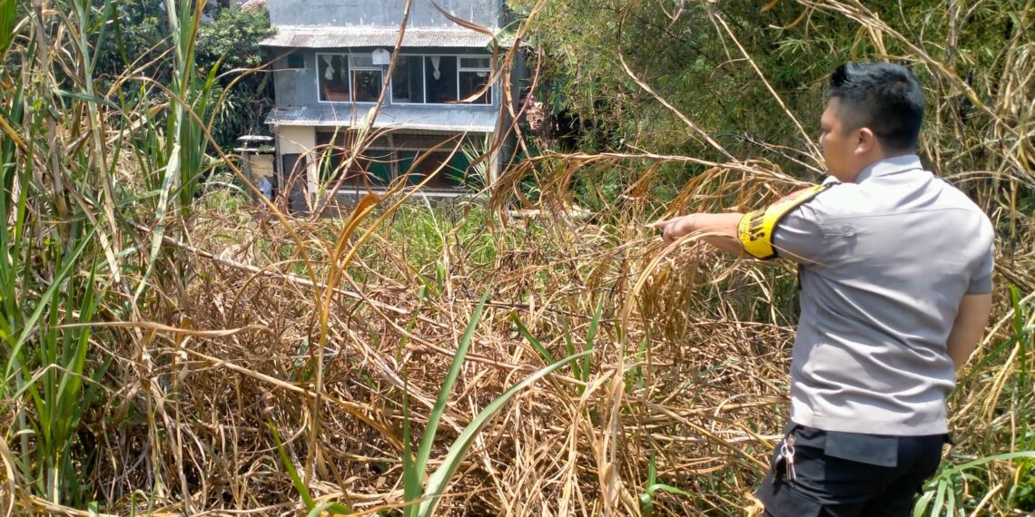 Bhabinkamtibmas Polsek Sukaraja dan masyarakat setempat membantu memadamkan api yang membakar lahan kering