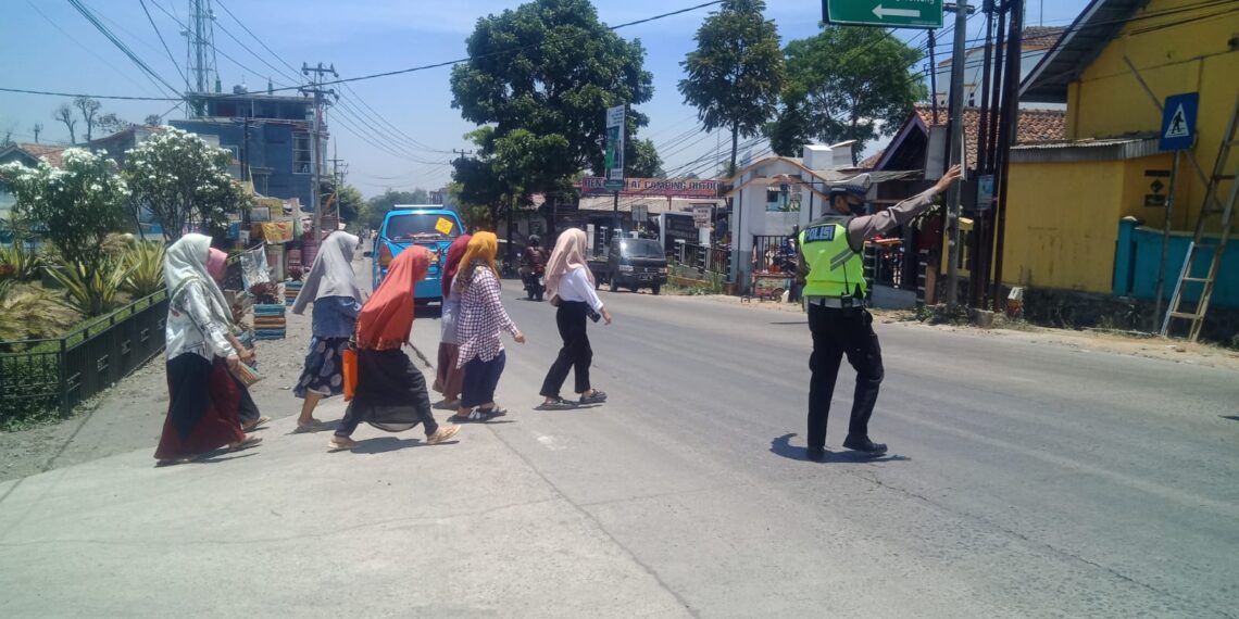 Unit Lantas Polsek Sukalarang Bantu Masyarakat Menyeberang Jalan