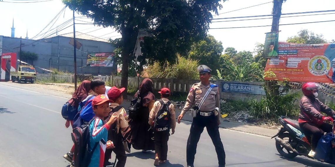 Aksi Humanis Anggota Polsek Sukalarang Bantu Siswa Sekolah Menyebrang Usai Pulang Sekolah