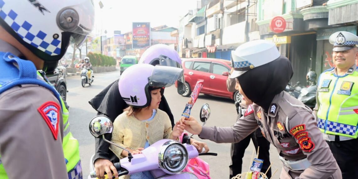 Bagikan Coklat dan Helm, Polwan dan Badut di Kota Sukabumi Ajak Warga Tertib Berlalulintas