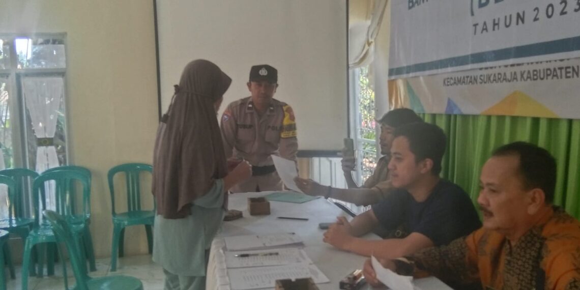 Anggota Bhabinkamtibmas Polsek Sukaraja bersama-sama dengan unsur Muspika Desa Selawangi pantau penyaluran BPNT oleh Desa,dan BLT DD