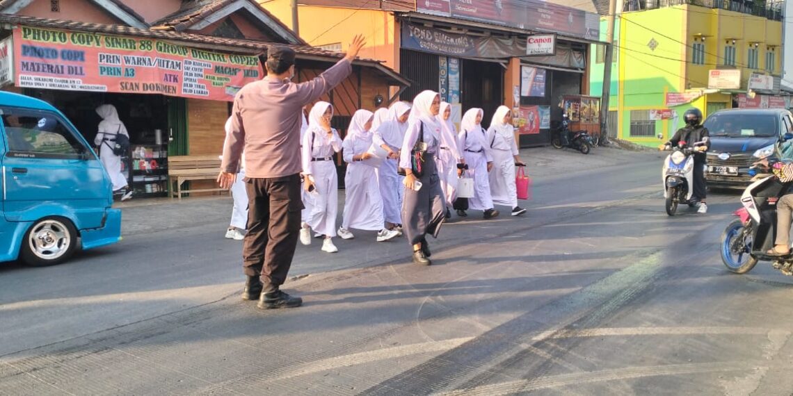 Wujud Kepedulian, Polisi Bantu Anak-Anak Sekolah Menyeberang Jalan Pasca Masuk Sekolah