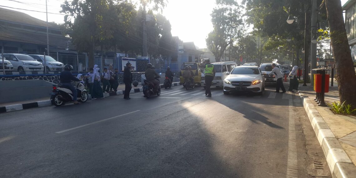 Lantas Polsek Cikole Bantu Sebrangkan Anak Sekolah