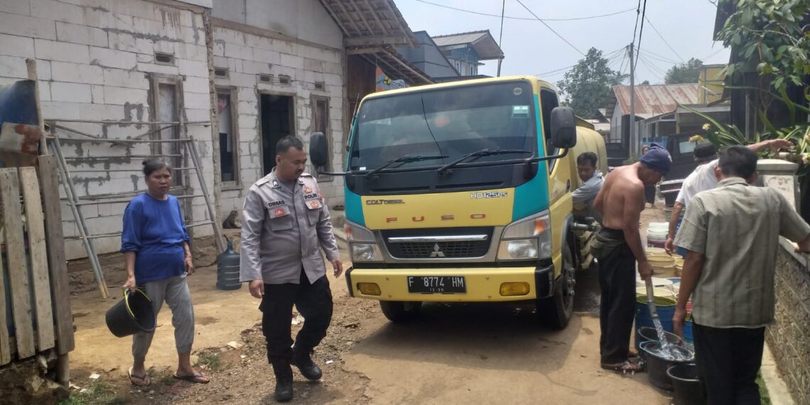 Dampingi Penyaluran Bantuan Air Bersih, Anggota Polsek Gunungguruh