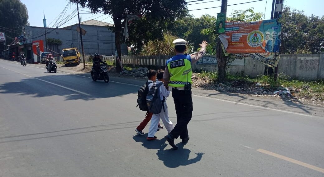 Polsek Sukalarang Bantu Anak-Anak Sekolah Menyeberang Jalan Sepulang Sekolah