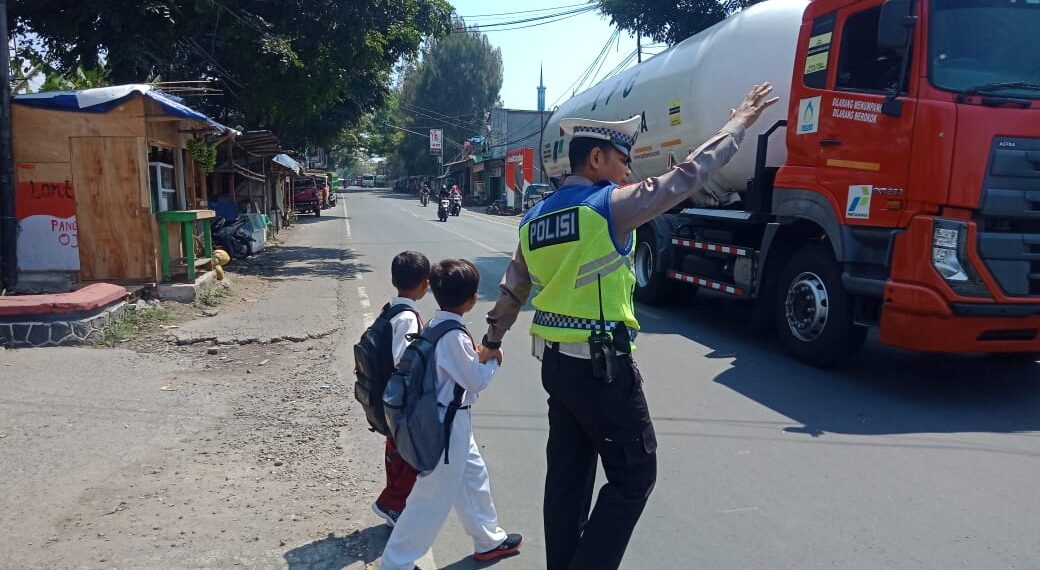 Wujud Kepedulian, Polisi Polsek Sukalarang Bantu Anak-Anak Sekolah Menyeberang Jalan Sepulang Sekolah