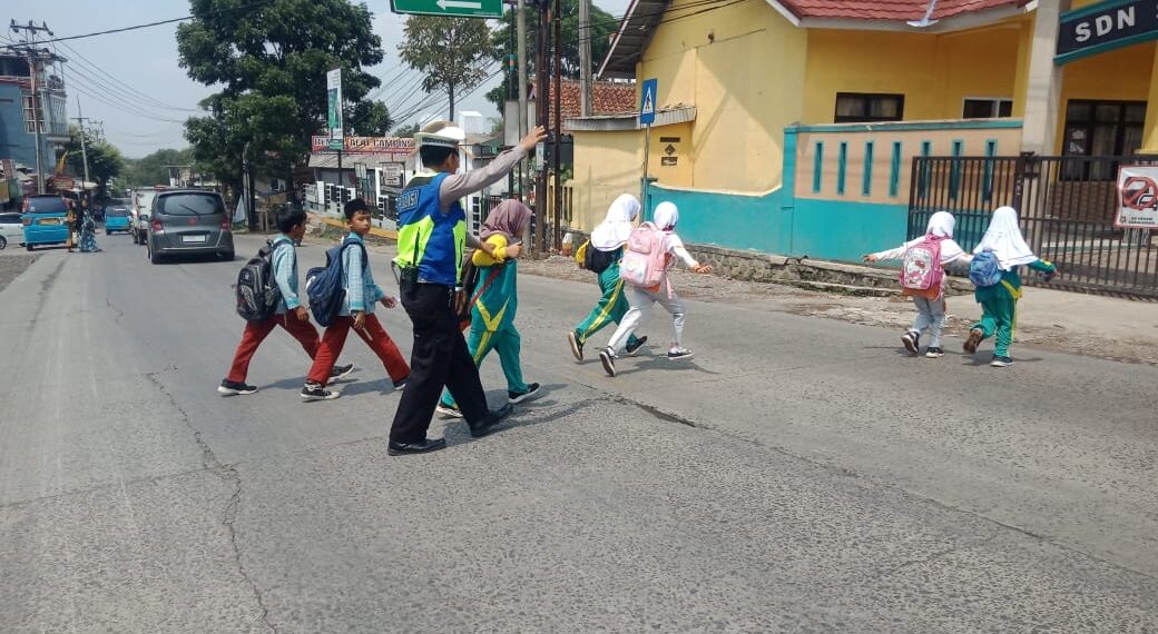 Wujud Kepedulian, Polisi Bantu Anak-Anak Sekolah Menyeberang Jalan