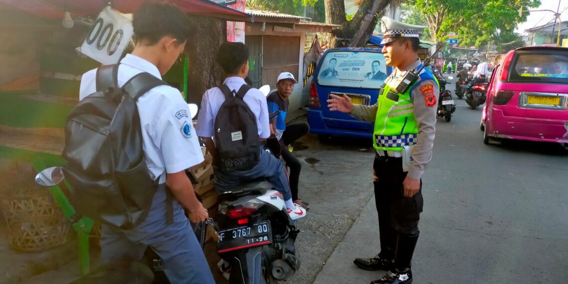 Personil Unit Lalu Lintas Polsek Sukaraja memberikan teguran secara humanis terhadap pelajar pengendara sepeda motor yang tidak menggunakan helm