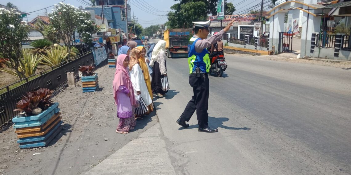 Unit Lantas Polsek Sukalarang Bantu Masyarakat Menyeberang Jalan