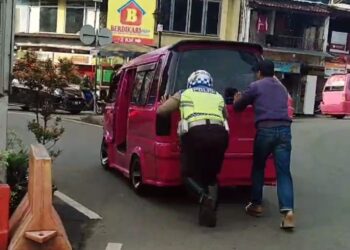 Bantu Dorong Mobil Angkot Yang Mogok Anggota Polsek Sukaraja