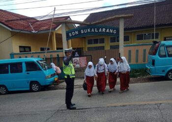 Berikan Rasa Aman dan Nyaman Bagi Pengguna Jalan Unit Lantas Polsek Sukalarang Bantu Pelajar Menyeberang Jalan