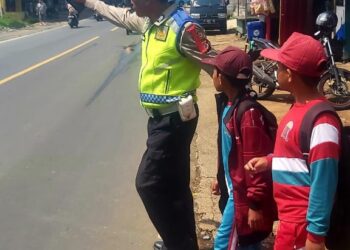 Aksi Humanis Anggota Polsek Sukalarang Bantu Siswa Sekolah Menyebrang Usai Pulang Sekolah