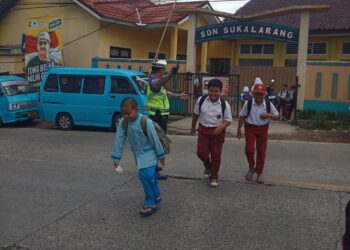 Unit Lantas Polsek Sukalarang Bantu Pelajar Menyeberang Jalan Berikan Rasa Aman dan Nyaman Bagi Pengguna Jalan