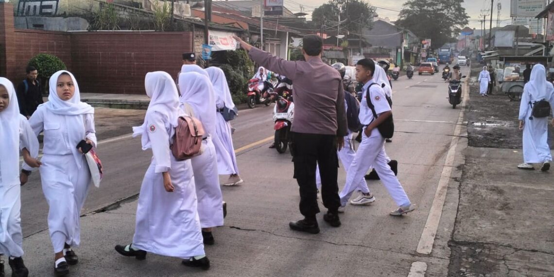 Wujud Kepedulian, Personil Polsek Sukalarang  Bantu Anak Sekolah Menyeberang Jalan