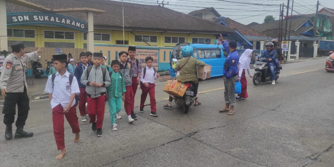 Wujud Kepedulian,Unit Samapta Polsek Sukalarang  Bantu Anak Sekolah Menyeberang Jalan