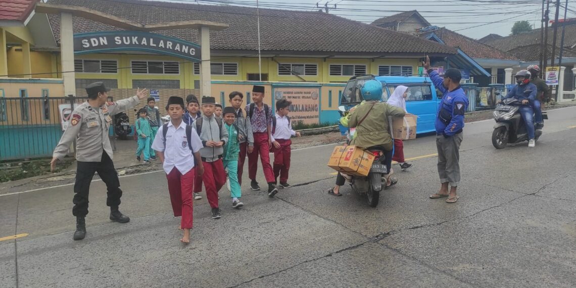 Wujud Kepedulian,Unit Samapta Polsek Sukalarang  Bantu Anak Sekolah Menyeberang Jalan