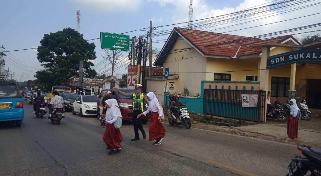 Wujud Kepedulian, Polisi Bantu Anak-Anak  Menyeberang Jalan Sepulang Sekolah