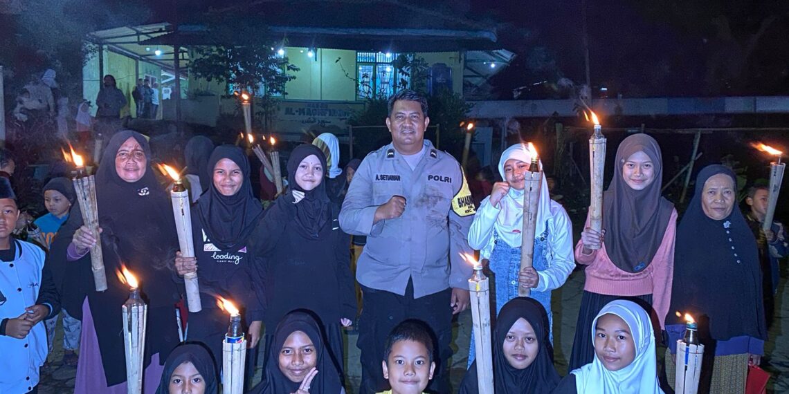 Sambut Tahun Baru Islam, Bhabinkamtibmas Bersama Babinsa Lakukan Pengamanan Jalur Pawai Obor.