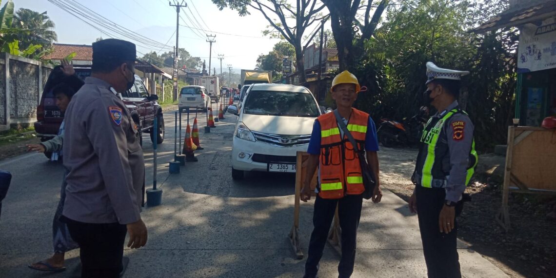 Personil Unit Lantas Polsek Sukalarang Atur Lalu Lintas di Lokasi Perbaikan Jalan