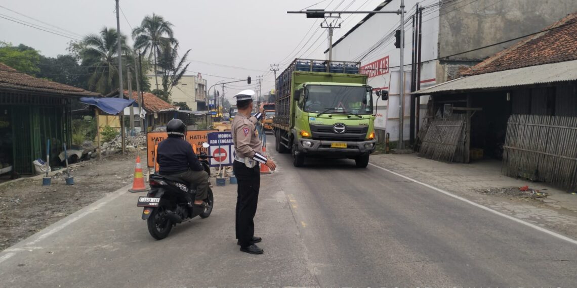 Anggota Unit Lantas Polsek Sukalarang Atur Lalu Lintas di Lokasi Perbaikan Jalan Nasional