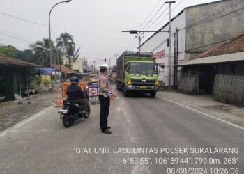 Anggota Unit Lantas Polsek Sukalarang Atur Lalu Lintas di Lokasi Perbaikan Jalan Nasional