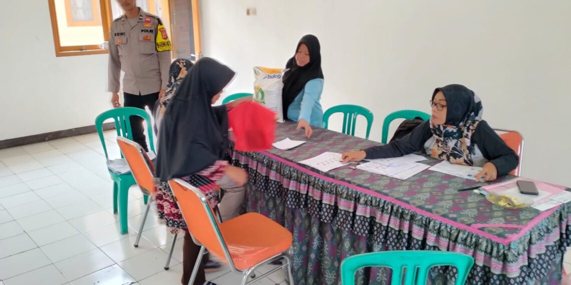 Jaga kondusif Bansos, Bhabinkamtibmas Jayaraksa Monitoring Penyaluran CBP di aula kelurahan Jayaraksa