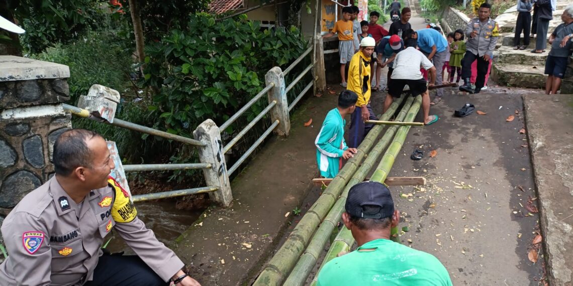 Kompak Dalam Kebersamaan. Bhabinkamtibmas Polsek Baros  dan Warga Gotong royong bangun Jambatan Darurat