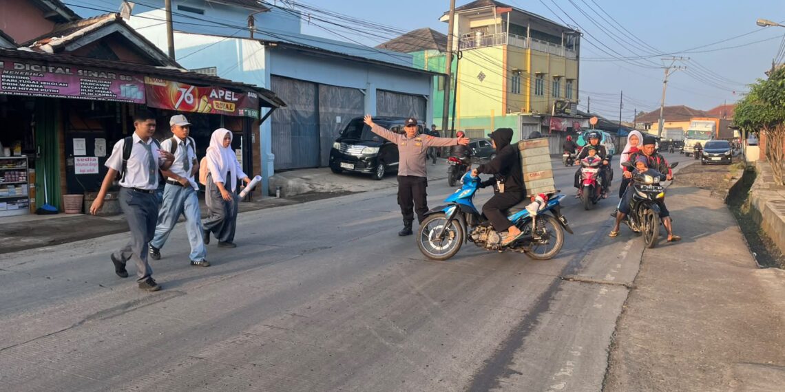 Polisi Atur Lalu Lintas dan Bantu Pelajar Menyeberang di Sukalarang